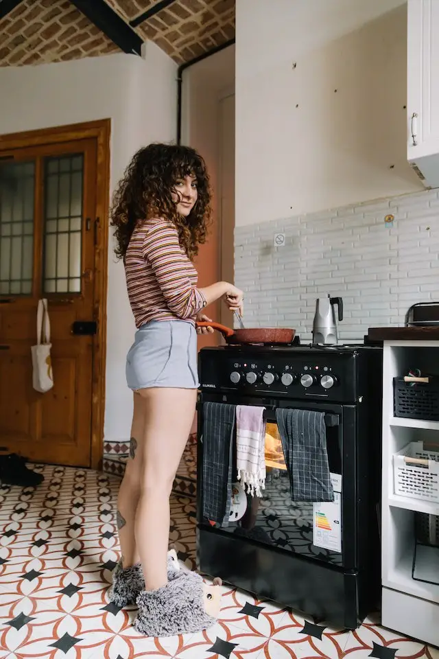 girl in front of oven reheating steak