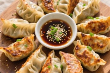 Cooking process: Overhead shot of freshly pan-fried gyoza arranged in a tight crescent around a cent
