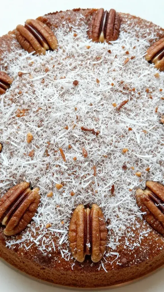 overhead of frosted cake top, coconut-pecan texture focus