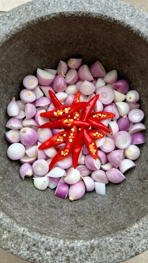 mortar holding chopped shallots and chilies, overhead