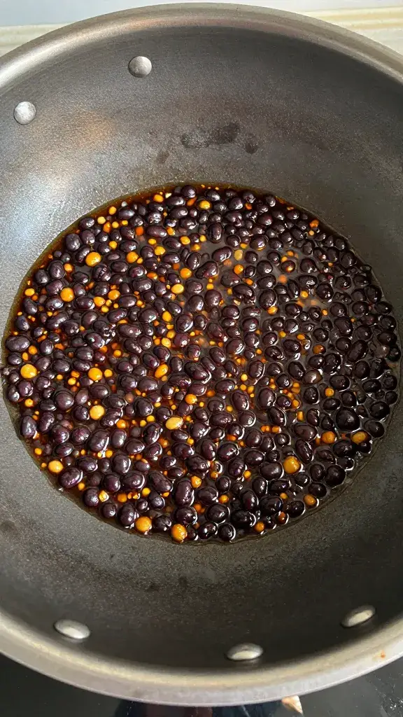 sizzling wok ladle coated in black bean garlic glaze