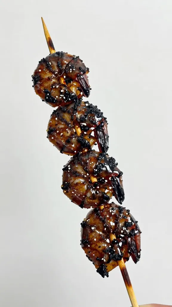 Blackened shrimp skewer tip with glossy wet glaze