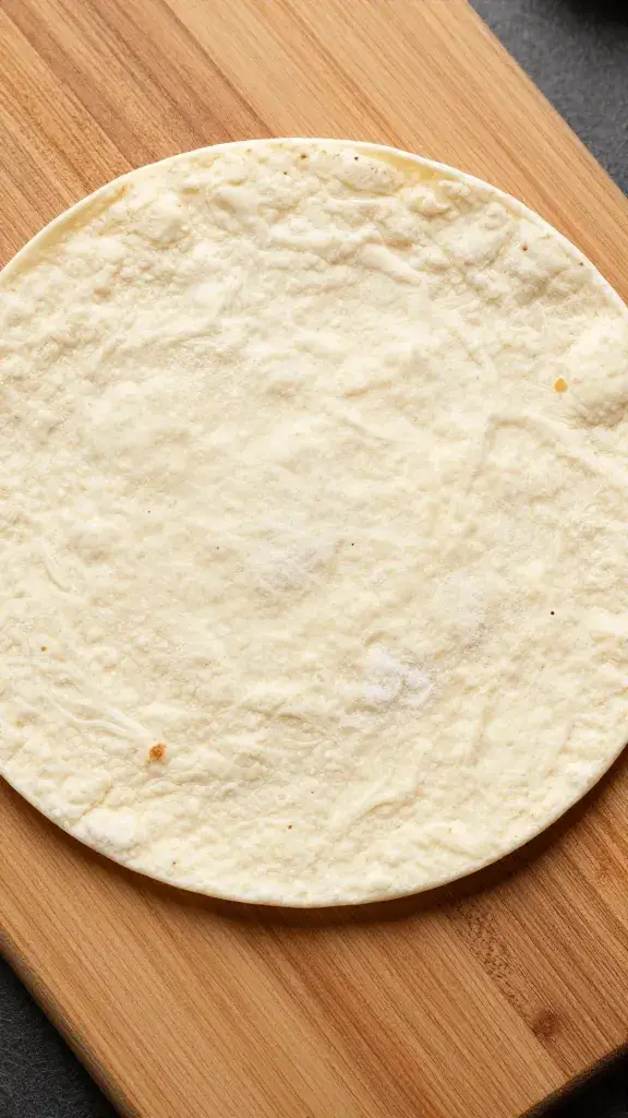 single 10-inch flour tortilla on wooden board