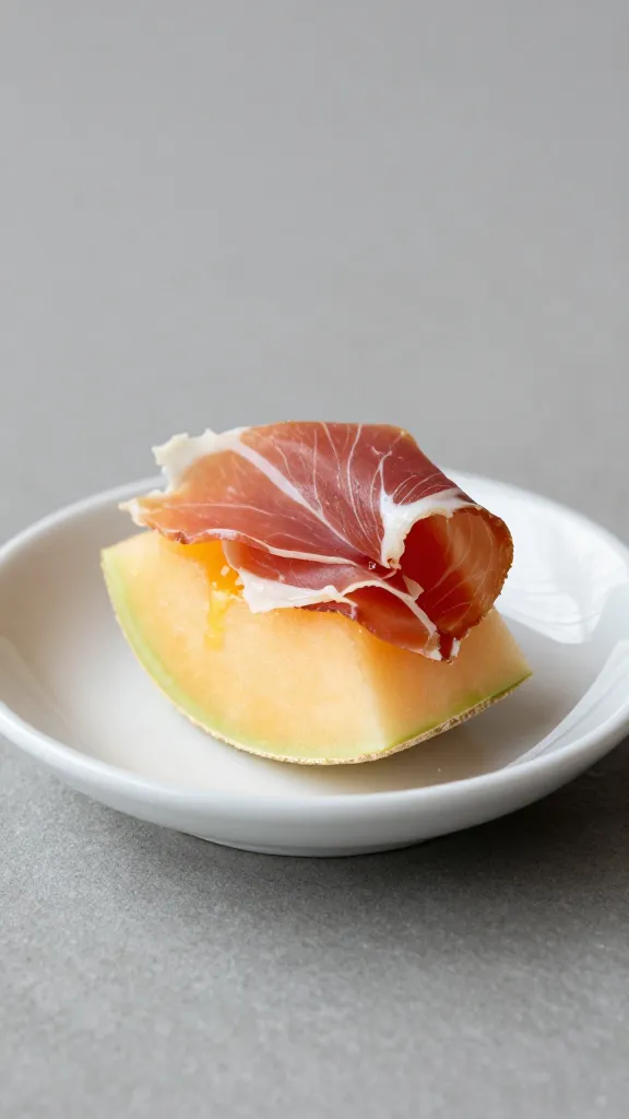 lemon-zested prosciutto melon bite on small porcelain dish