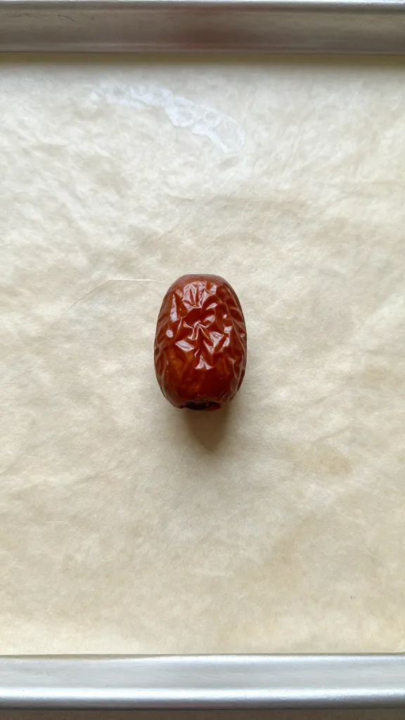 baking sheet with one stuffed date center-focused