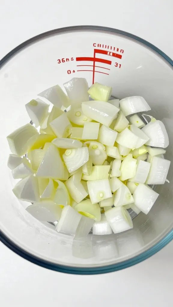 Measuring cup filled with diced onions, overhead