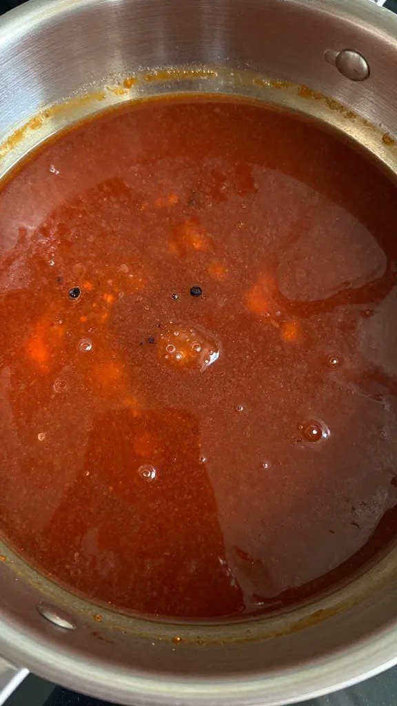 closeup saucepan of simmering BBQ sauce reducing