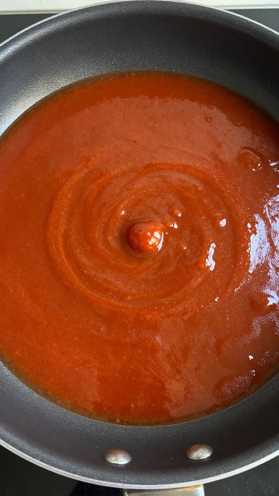 saucepan simmering fair-style bbq sauce, thick glossy surface