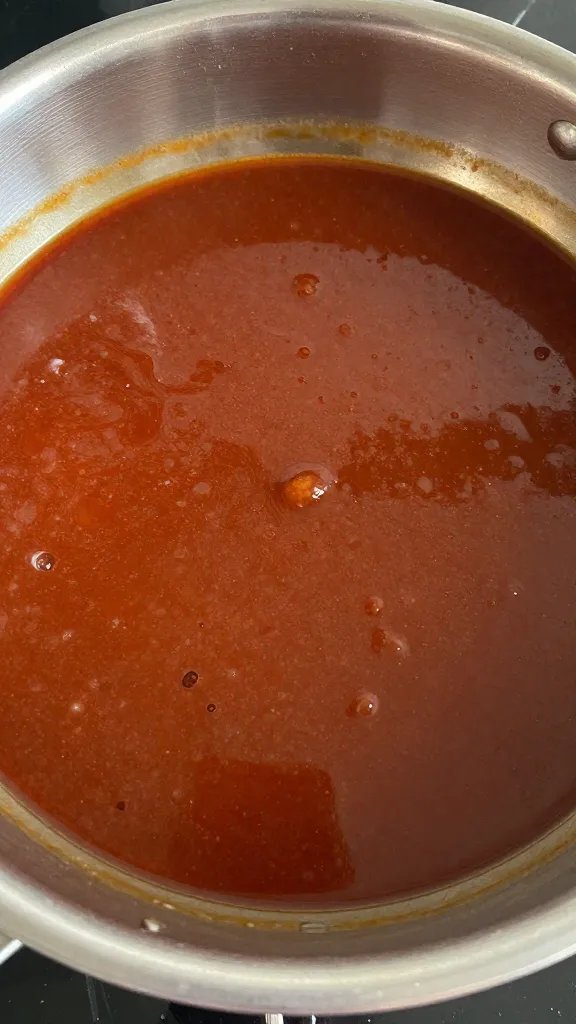 saucepan of simmering BBQ sauce with visible pectin sheen