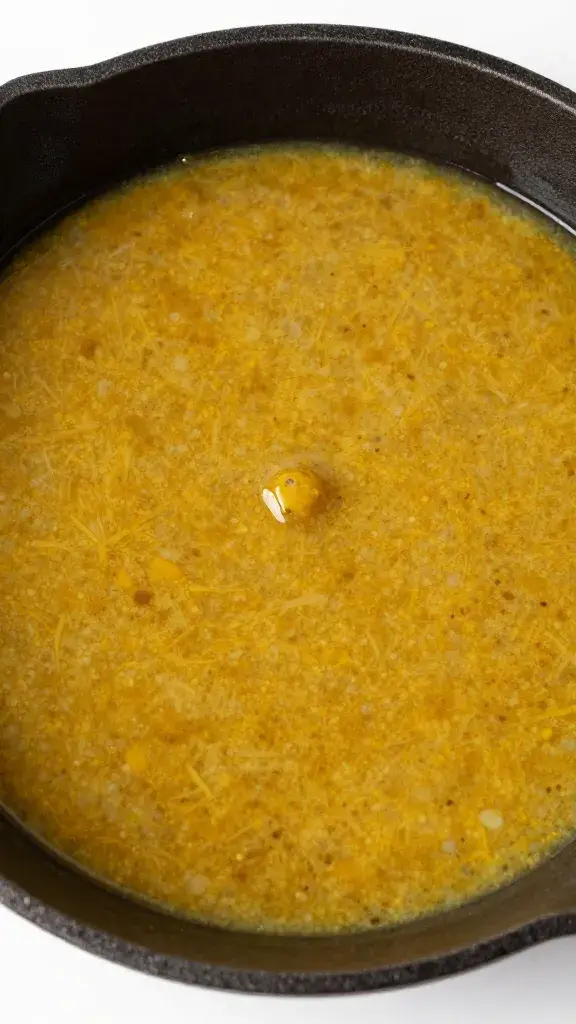 cast-iron bowl of marinade with visible curry specks