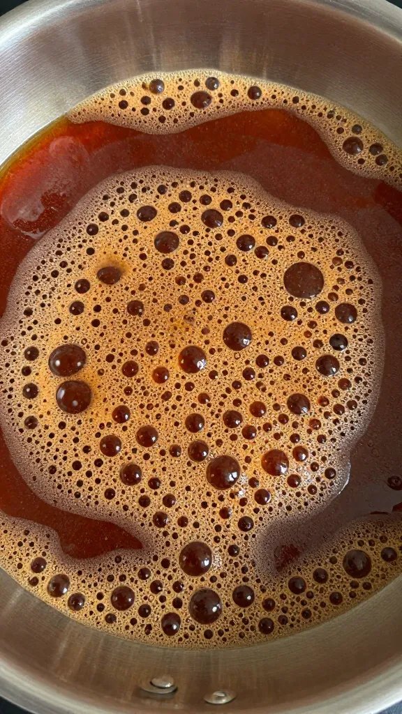 saucepan of simmering keto bbq sauce, bubbles visible