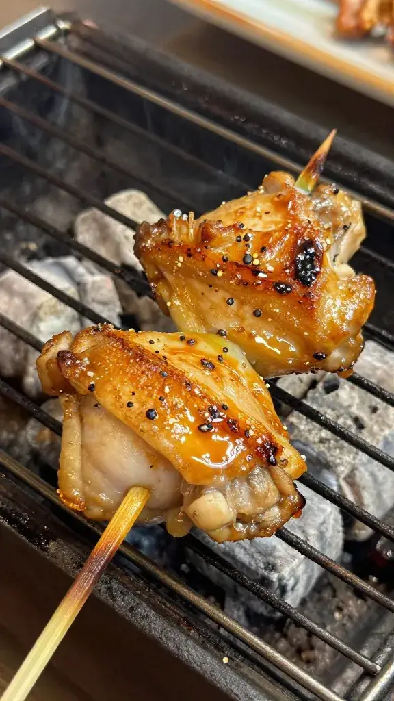 glazed chicken thigh yakitori skewer closeup over charcoal