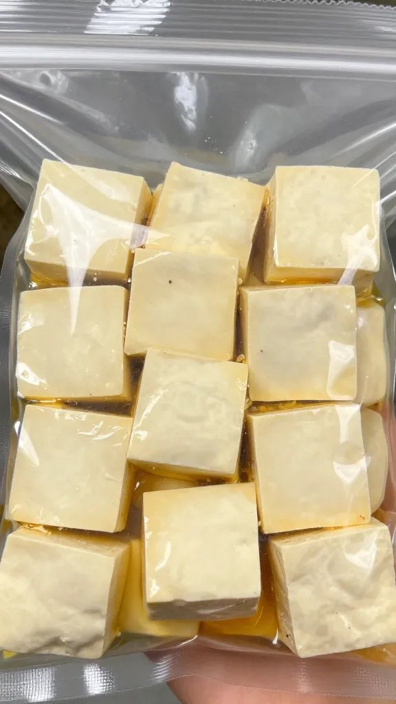 closeup of marinated tofu cubes in zip-top bag