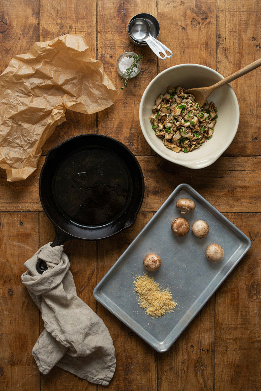 Stuffed mushroom making tools arranged on rustic table
