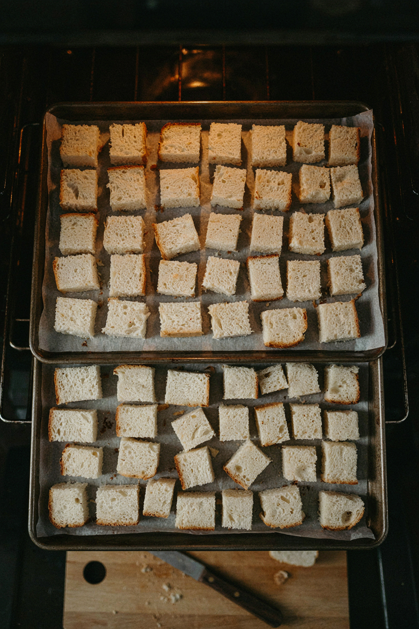 Bread cubes drying on baking sheets