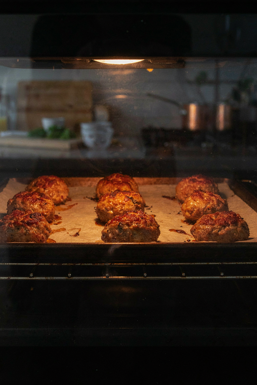 Turkey meatballs on baking sheet in oven, golden brown